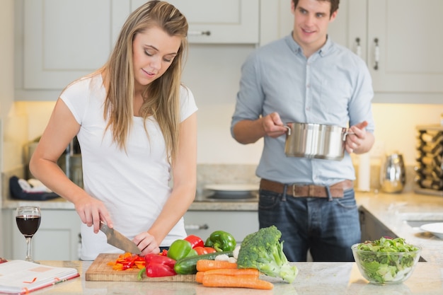 Homem que ajuda mulher com cozinhar