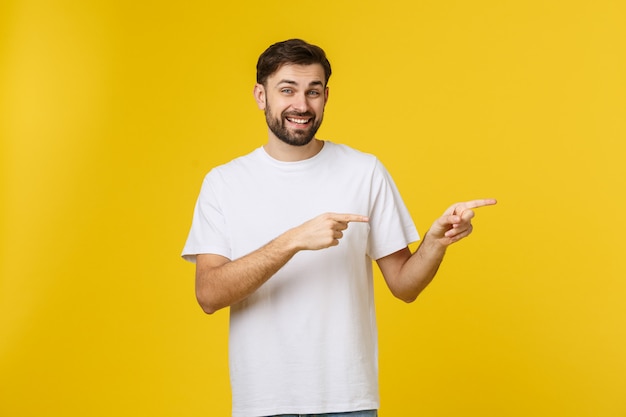 Homem que aponta mostrando o espaço da cópia isolado. Casual bonito caucasiano jovem.