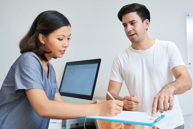 Homem que consulta com recepcionista