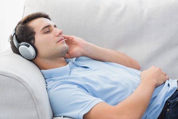 Foto homem que gosta de música deitada em um sofá