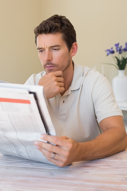 Foto homem que lê jornal em casa