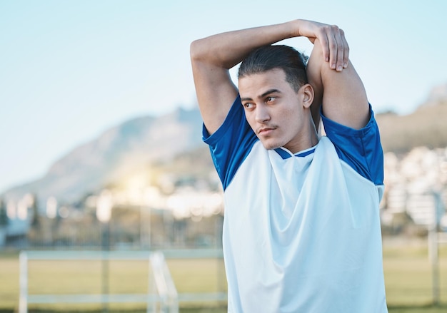 Homem que pensa ou jogador de futebol esticando os braços no campo de futebol em exercício de treinamento ou treino no Brasil Fitness aquece ou atleta masculino pronto para começar a prática ou jogo esportivo no estádio