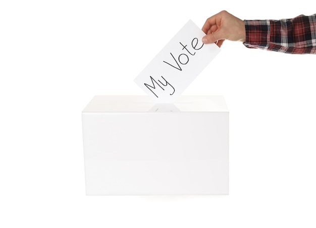 Homem que põe seu voto na urna no close up branco do fundo
