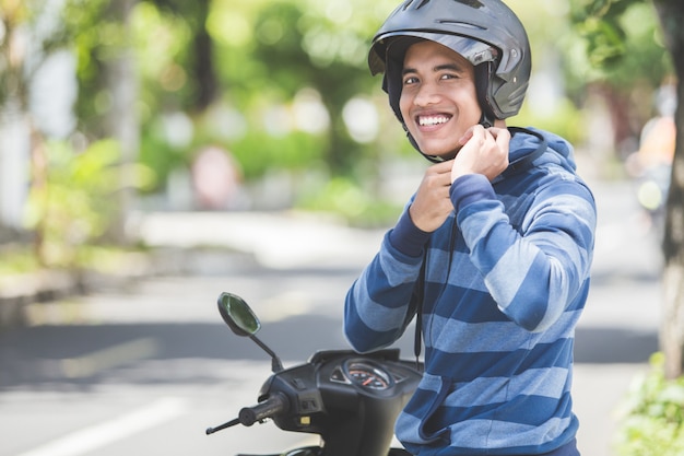 Homem que prende seu capacete de moto