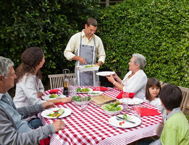 Homem que serve a sua família na mesa