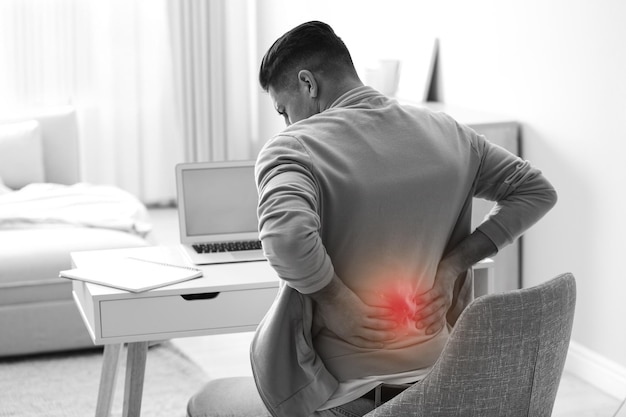 Foto homem que sofre de dor nas costas no local de trabalho problema de má postura