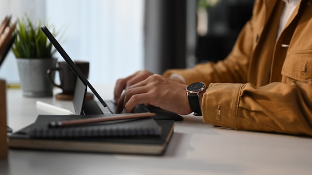 Homem que sofre de internet com computador tablet no espaço de trabalho do escritório em casa.