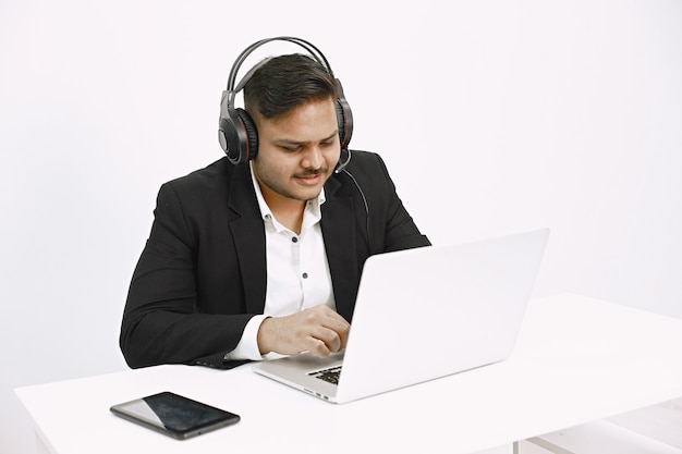 Homem que trabalha com o laptop. Expedidor indiano ou trabalhador de linha direta.