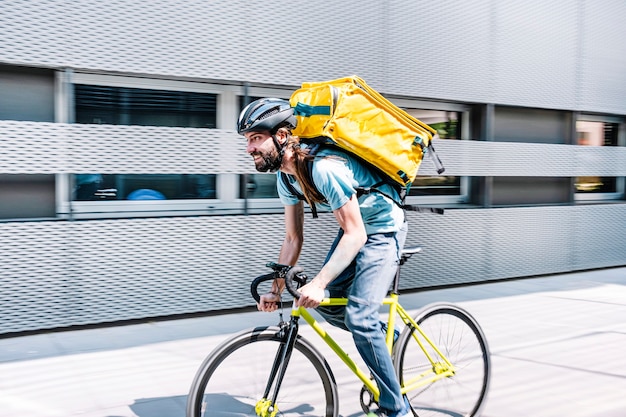 Foto homem que trabalha entregando comida por correio em alta velocidade pela cidade.