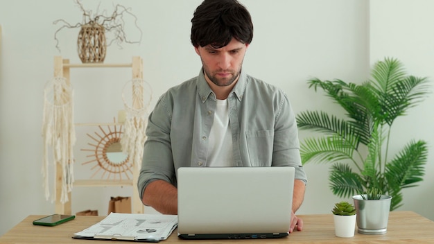 Homem que trabalha no escritório usando o laptop no escritório. jovem profissional verificando e-mail e enviando cartas