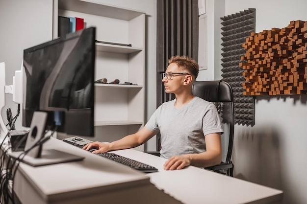 Homem que trabalha no estúdio de música usando o computador usando óculos engenheiro de som trabalhando e mixando a faixa programador assistindo a exibição enquanto ouve música conceito de tecnologia