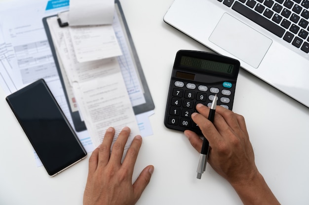 Homem que usa a calculadora com o escritório da finança em casa.