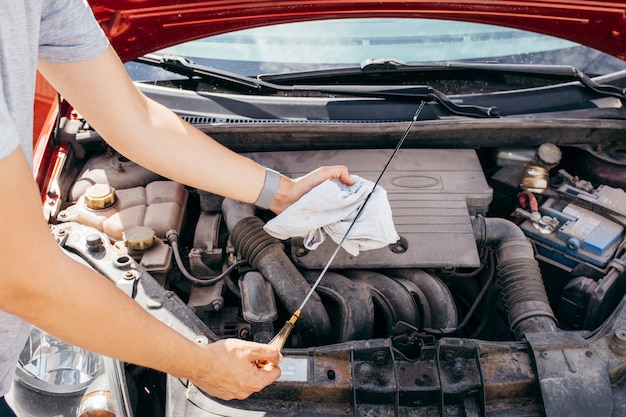 Foto homem que verifica o óleo de motor em um carro