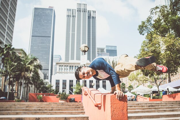 Homem realizando truques de parkour no centro urbano