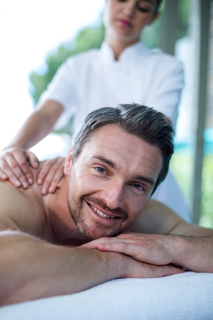 Foto homem recebendo massagem nas costas do massagista