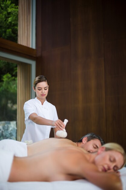 Homem recebendo massagem nas costas do massagista