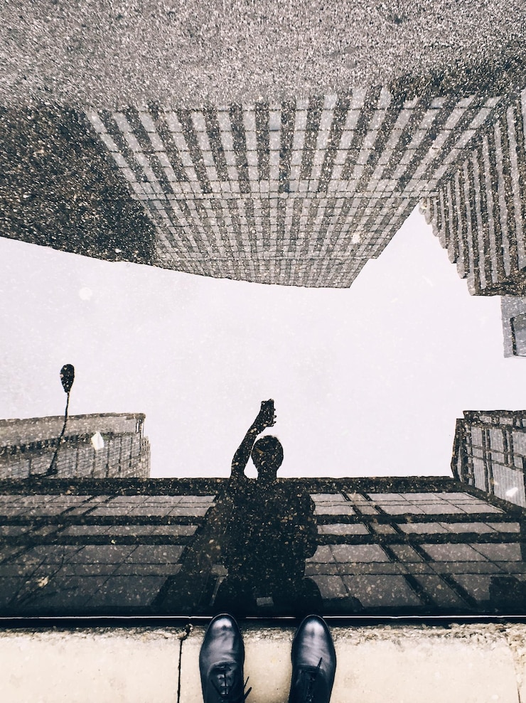 Foto homem refletindo-se na poça