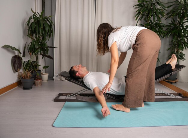 Foto homem relaxado aprendendo poses de ioga com o professor