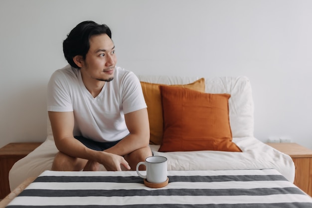 Homem relaxado com café na sala de estar do apartamento