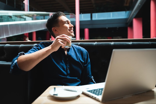 Homem relaxando e desfrutando de uma xícara de café fazendo uma pausa no trabalho Homem sentado na mesa de café