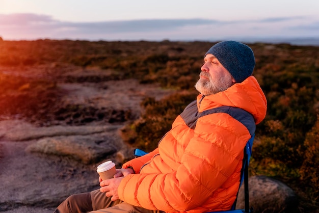 Homem relaxando sozinho no topo da montanha O parque nacional Peak District na Inglaterra