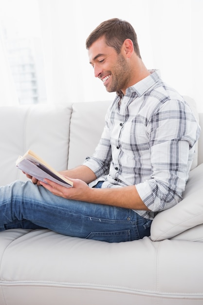 Homem relaxante em um sofá com um livro