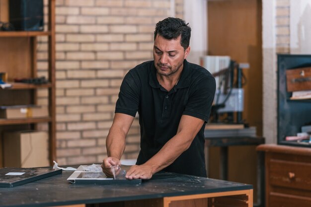 Homem removendo a fita plástica protetora de um móvel