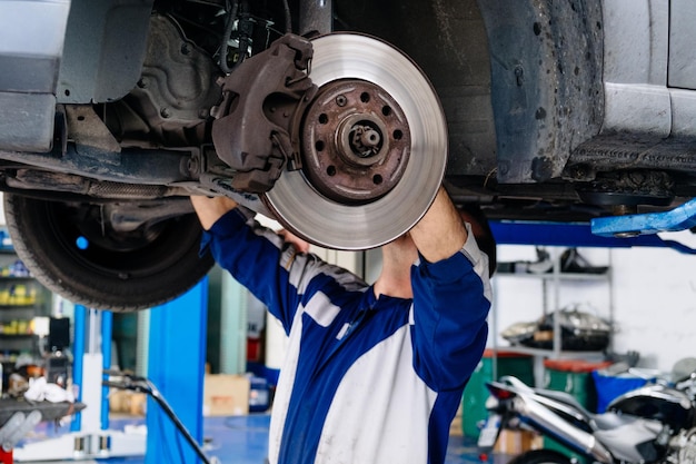 Foto homem reparando carro em uma oficina de reparação de automóveis