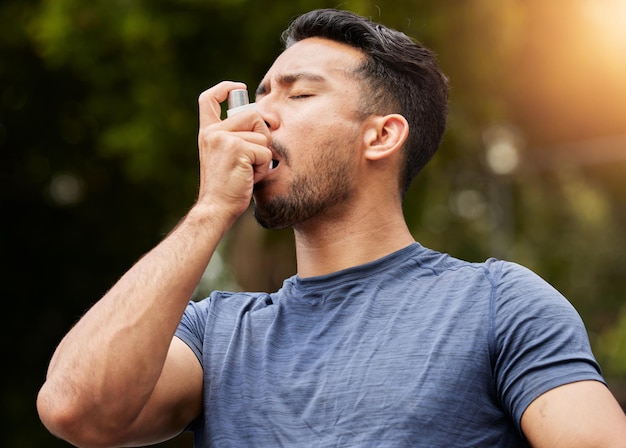 Homem respira ou bomba de asma ao ar livre no parque para ajudar com risco de saúde, tratamento de tosse e ar para exercícios, spray de corredor masculino asiático e inalador de remédios na natureza para oxigênio e bem-estar dos pulmões