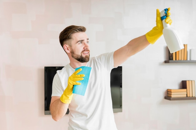 Homem rezando a casa com produto de limpeza