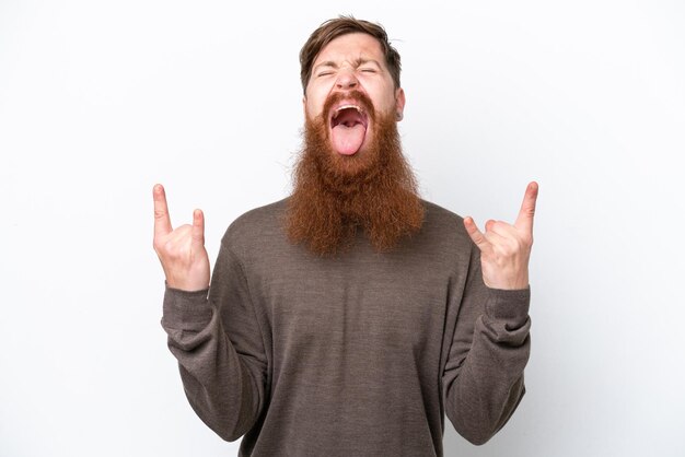 Homem ruivo com barba isolada no fundo branco fazendo gesto de chifre