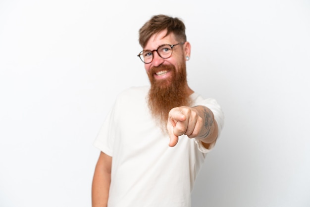 Homem ruivo com barba longa, isolado no fundo branco, apontando para a frente com expressão feliz