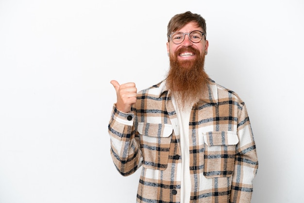 Foto homem ruivo com barba longa, isolado no fundo branco, apontando para o lado para apresentar um produto