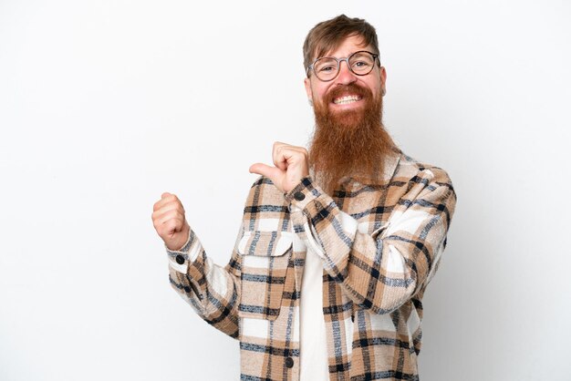 Homem ruivo com barba longa, isolado no fundo branco, apontando para o lado para apresentar um produto