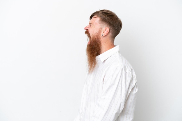Homem ruivo com barba longa, isolado no fundo branco, rindo em posição lateral