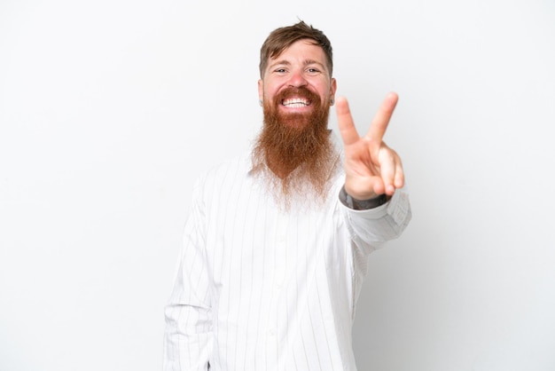 Homem ruivo com barba longa, isolado no fundo branco, sorrindo e mostrando sinal de vitória