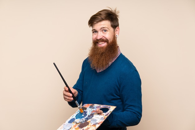 Homem ruivo com barba longa, segurando uma paleta
