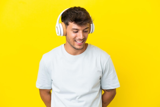 Homem ruivo sobre parede azul posando com os braços no quadril e sorrindo