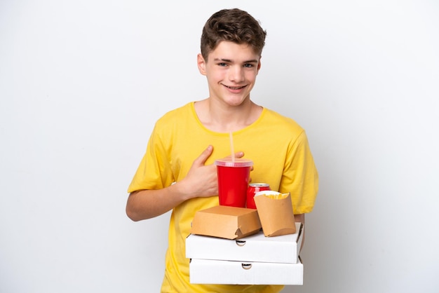Homem russo adolescente segurando fast food isolado no fundo branco sorrindo muito