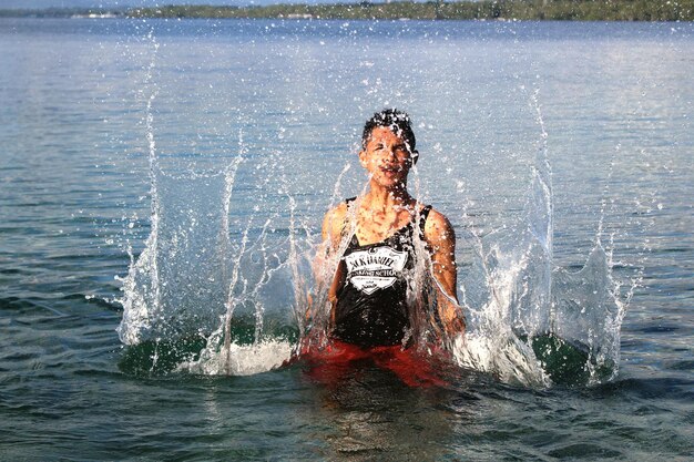 Foto homem salpicando água no mar