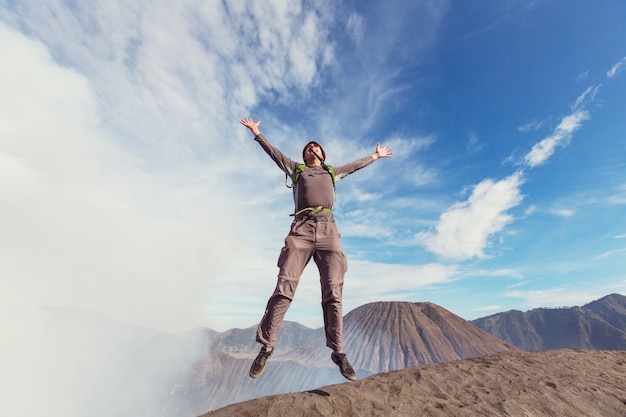 Homem saltando em montanhas vulcânicas, bromo, indonésia