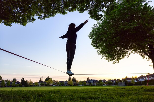 Foto homem saltando no campo contra o céu durante o pôr do sol