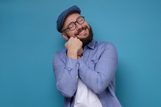 Homem se abraçando sorrindo e com os olhos fechados imaginando algo agradável