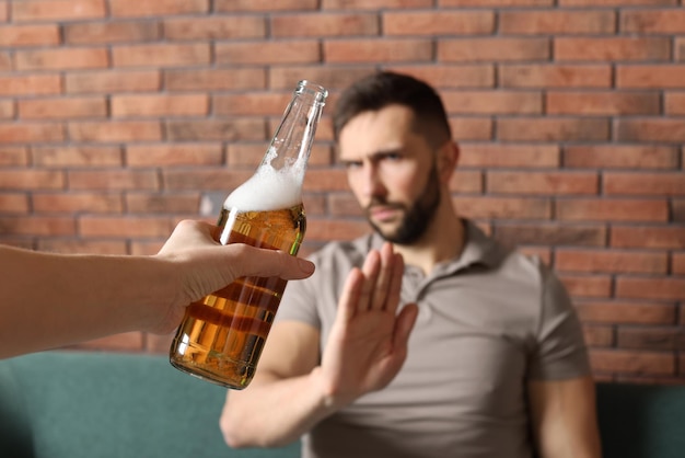 Foto homem se recusando a beber cerveja dentro de casa tratamento de dependência de álcool