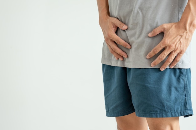 Foto homem segura a mão na frente de partes íntimas, sentindo desconforto devido a doenças e inflamações câncer testicular venéreo problemas de bexiga disfunção erétil ejaculação precoce câncer de próstata