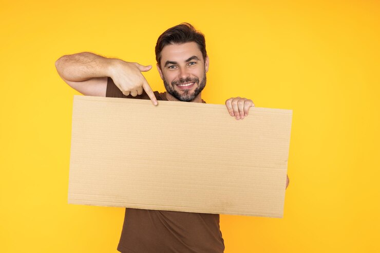 Foto homem segura cartão em branco placard pronto para o seu produto homem mostrando cartaz em branco sobre estúdio isolado fundo apontando dedo tabuleiro em branco vazio área para espaço de cópia publicitária