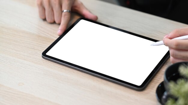 Homem segurando a caneta stylus apontando na tela vazia do tablet digital.