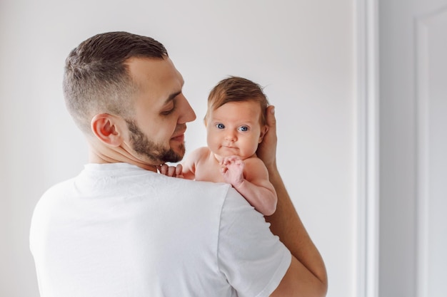 Homem segurando bebê em casa