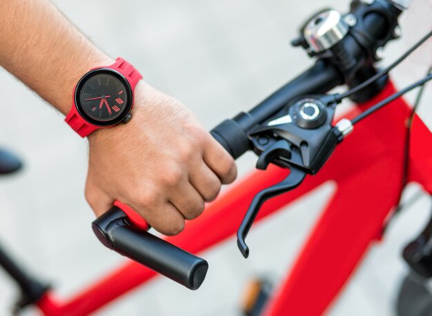 Homem segurando bicicleta vermelha de perto