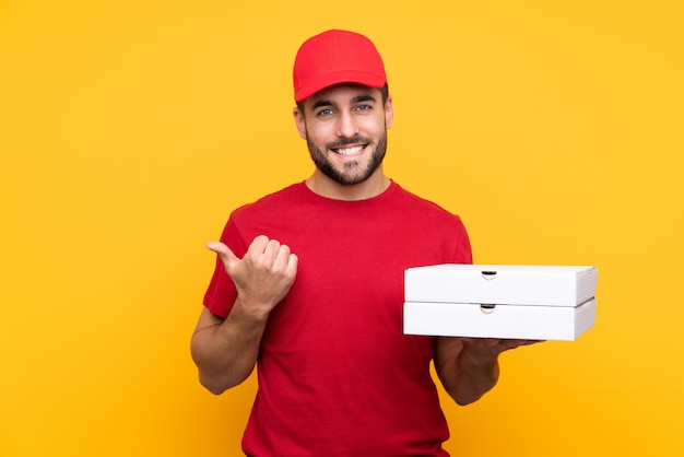 homem segurando caixas de pizzas sobre parede isolada
